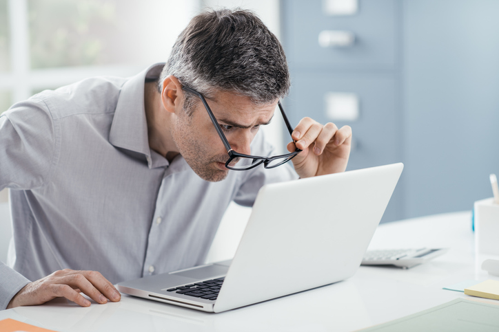 Het probleem is lezen - de man achter de computer kan niet goed zien zonder bril