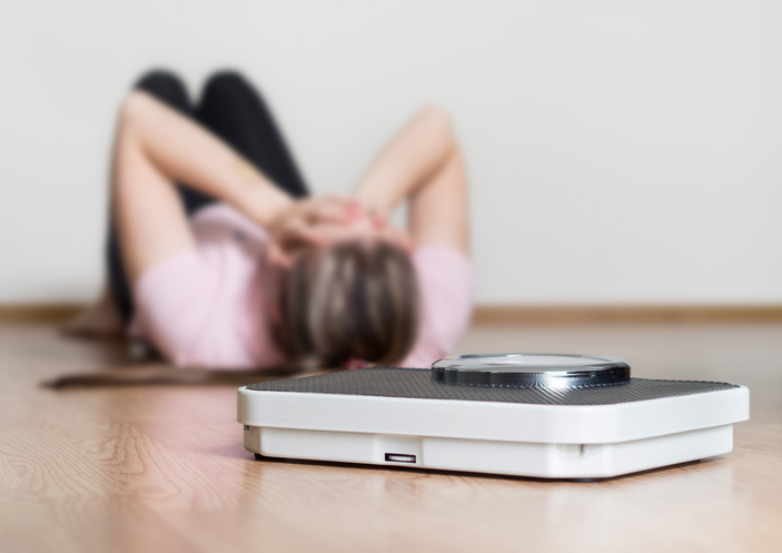 Boulimia - een vrouw die op de grond ligt, gewicht, lichaamsgewicht, angst