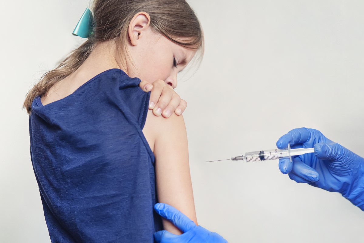 Vaccinatie van een kind - meisjes - de arts injecteert het vaccin in de schouder