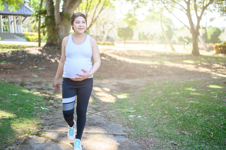 Zwangere vrouw loopt in het park.