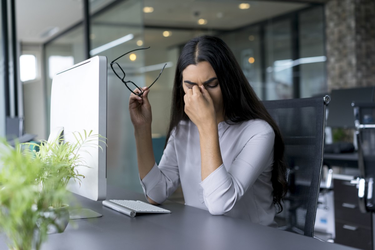 Hoofdpijn, vermoeidheid, een vrouw zittend aan een tafel