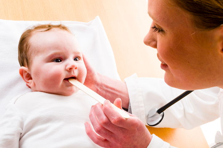 baby met open mond, moeder kijkt in zijn keel met een hamer