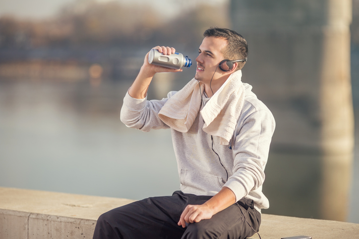 Een atleet drinkt water uit een fles