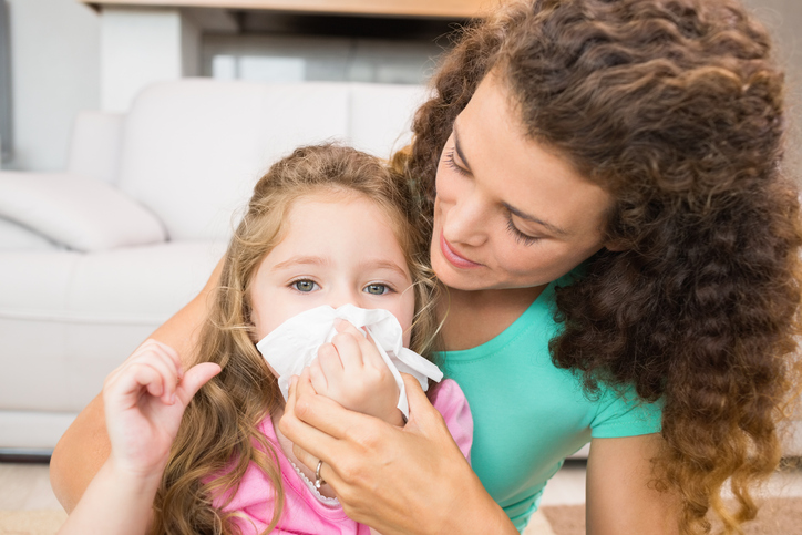 Het kind heeft een loopneus, de moeder snuit zijn neus vol met afscheiding, een volle neus voor allergieën