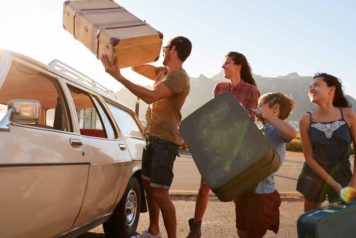 familie pakt koffers in de auto voor een vakantie