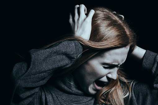 de vrouw houdt haar haar vast en schreeuwt, ze is agressief