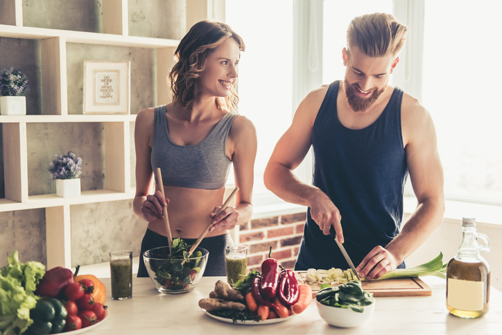 Een man en een vrouw bereiden een gezonde maaltijd in de keuken.