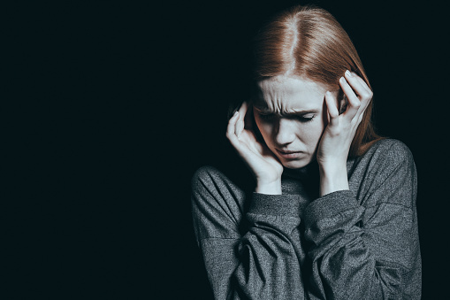 de vrouw houdt haar hoofd vast, ze is bang