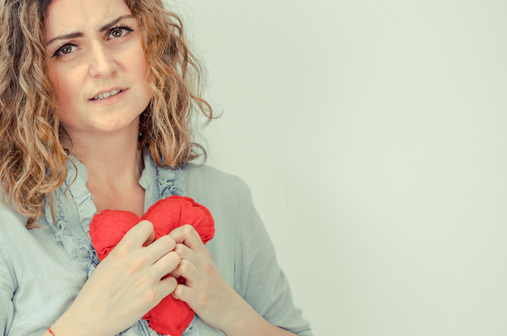 vrouw die een rood pluchen hart vasthoudt