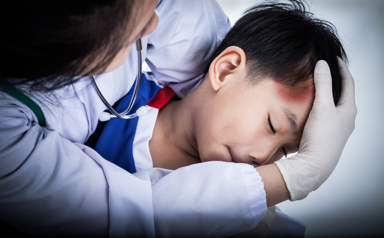 een kleine jongen heeft een hoofdwond, zijn voorhoofd is gekneusd, een dokter onderzoekt hem