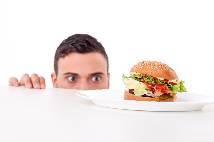 Man heeft trek, er ligt een hamburger op zijn bord