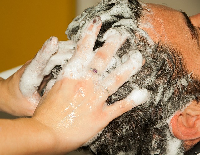 mannen wassen hun haar en laten hun hoofd wassen met shampoo, handen in het haar