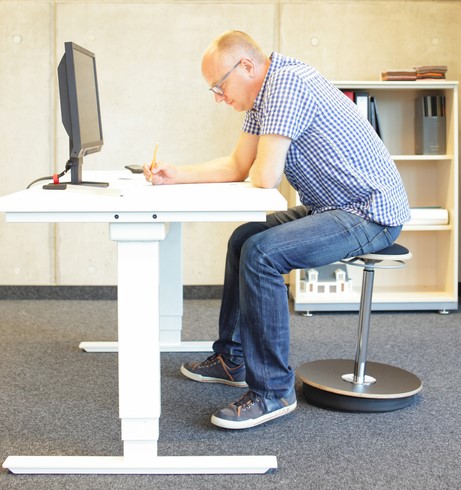 Man zit aan computerbureau, heeft zittend beroep