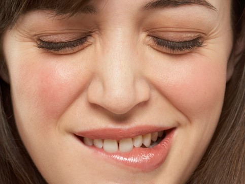 De vrouw bijt op haar lip, haar ogen zijn gesloten