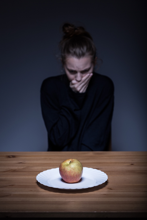 Vrouw weigert eten, er ligt een appel op het bord, walgelijk