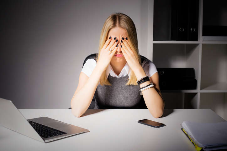 Vrouw heeft vermoeide ogen, lang achter de computer werken, droge-ogensyndroom